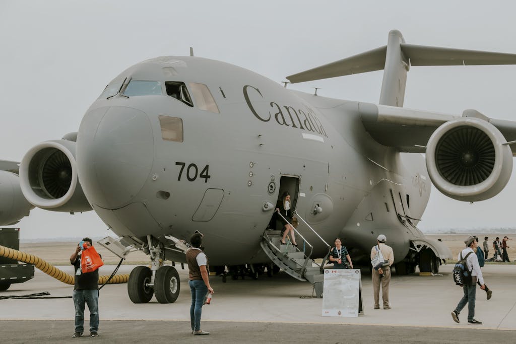 C-17 Globemaster aircraft on display at airshow with people disembarking.