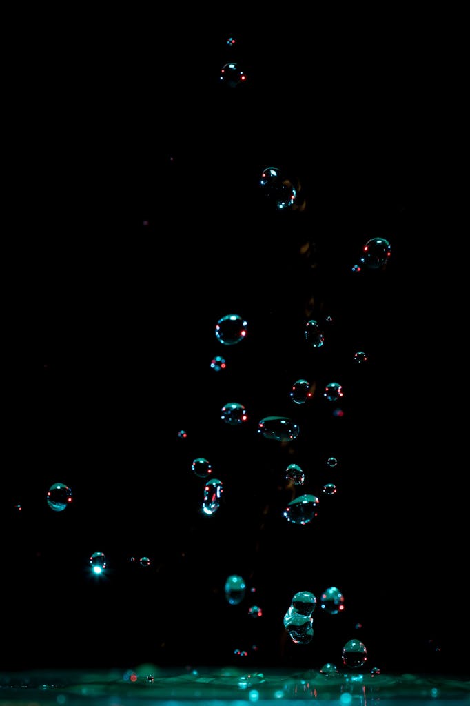 Captivating photo of water bubbles suspended in motion against a dark background.